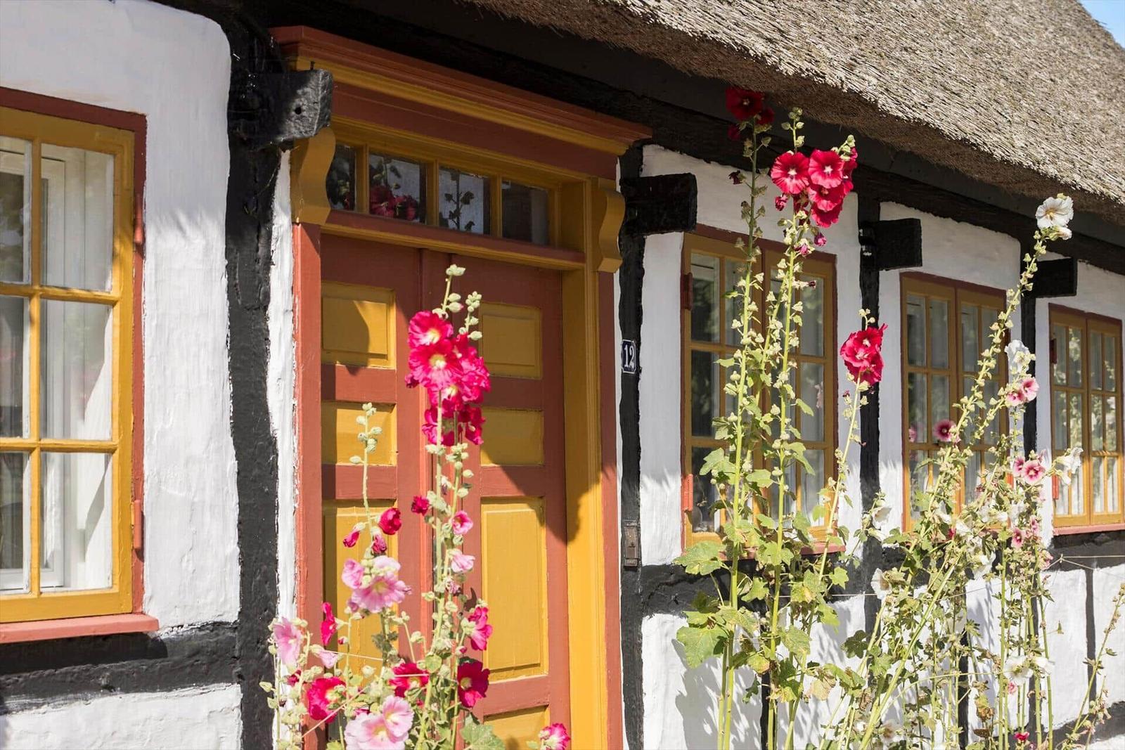 Weiße Kapelle mit rotem Dach, Fahrräder und Kinderwagen vor Ort