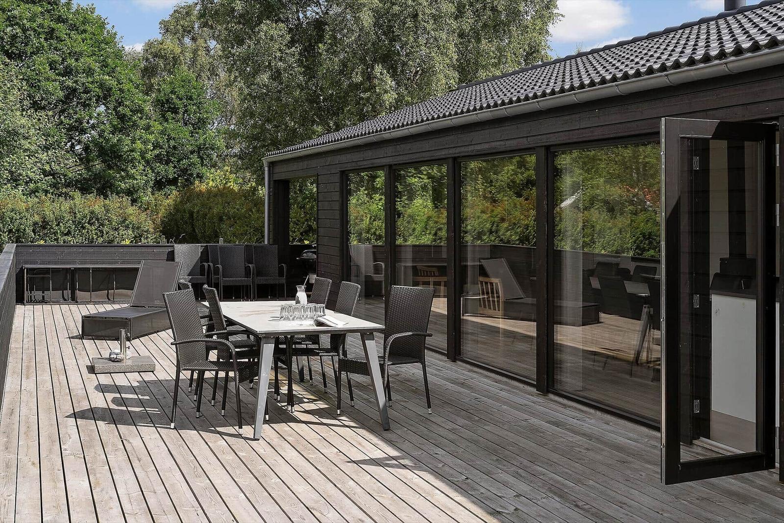 Modern wooden cabin with terrace and garden. Number 18. Surrounded by trees.