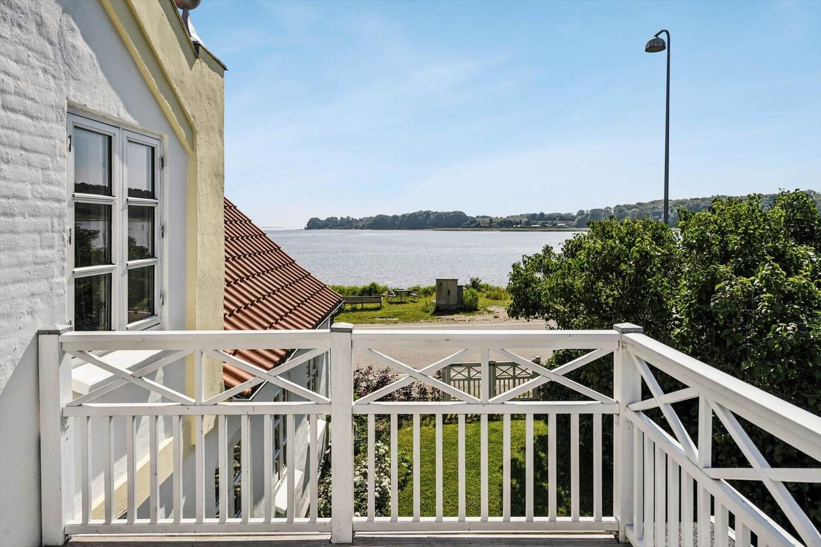 View from balcony over water, marina, road, and green areas.