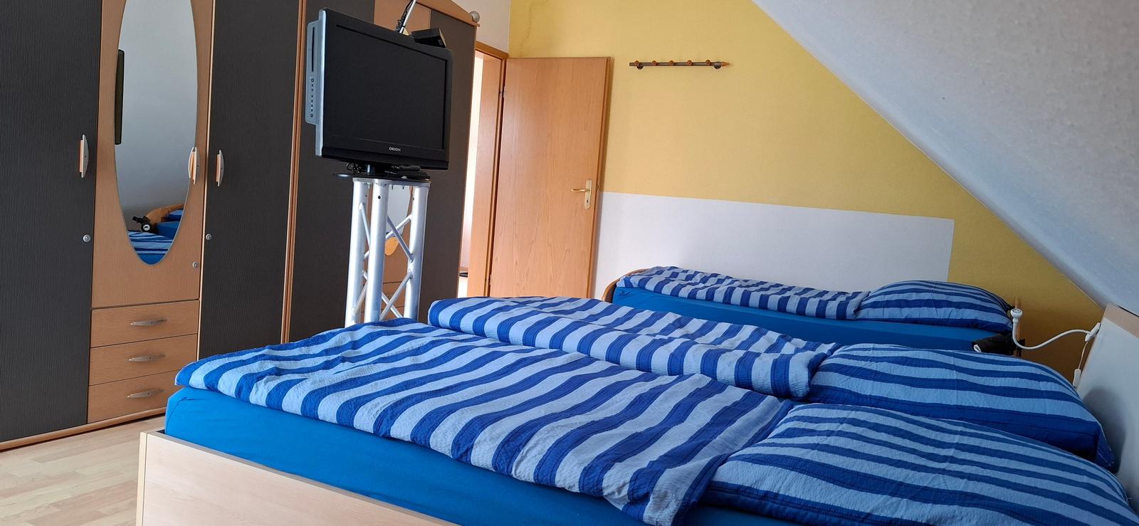 Großes Schlafzimmer mit einem Doppelbett und einem Einzelbett