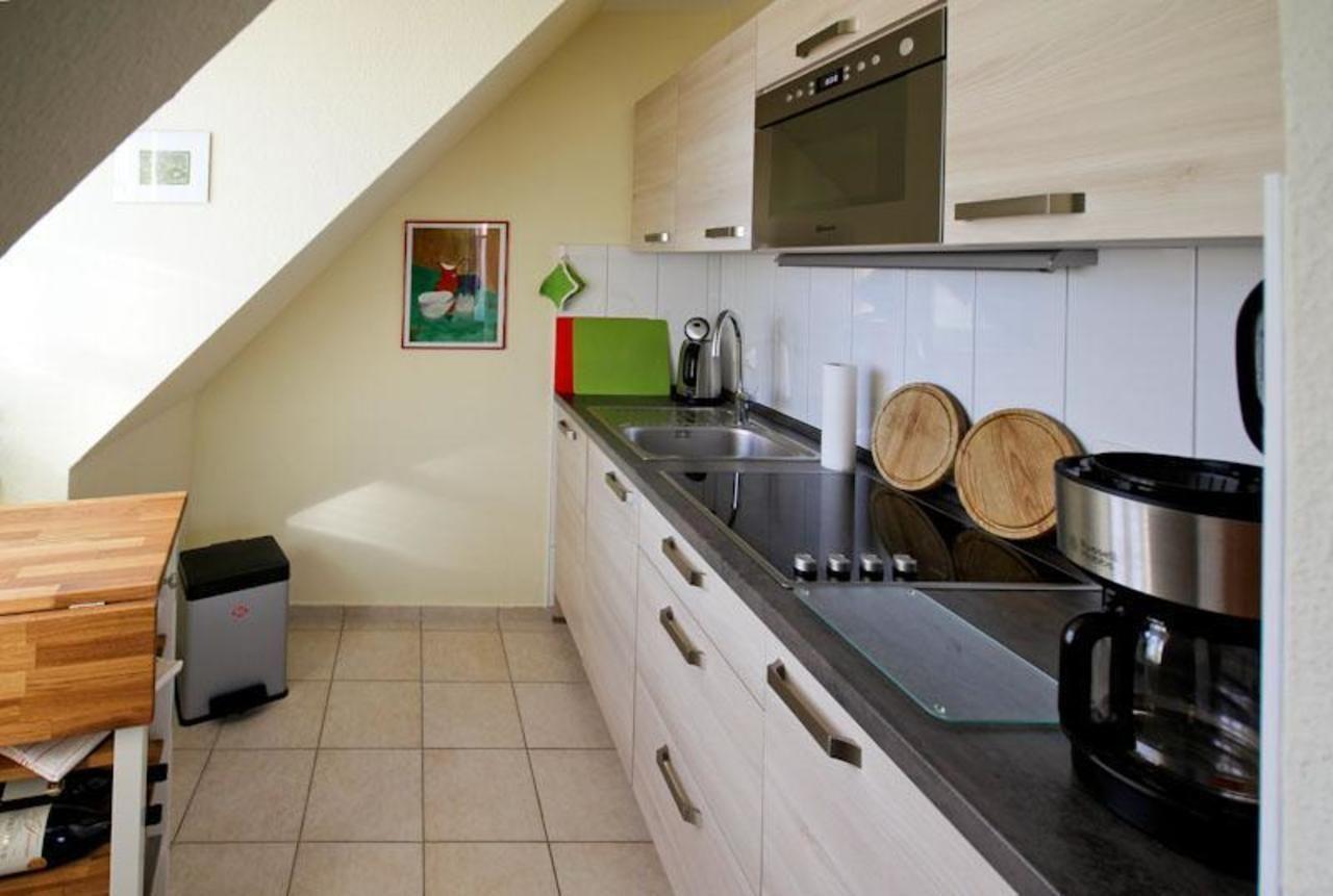 Küche mit Dunstabzug, Spüle, Herd und Kühlschrank unter Dachschrägen.