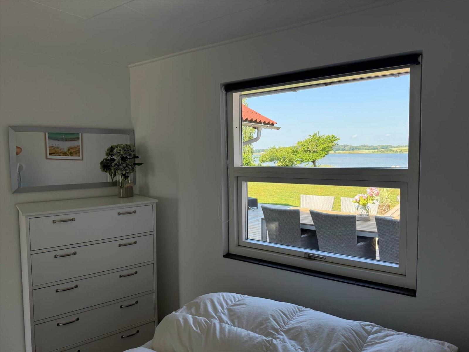 Apartment with kitchen, bathroom, and two bedrooms with beds.