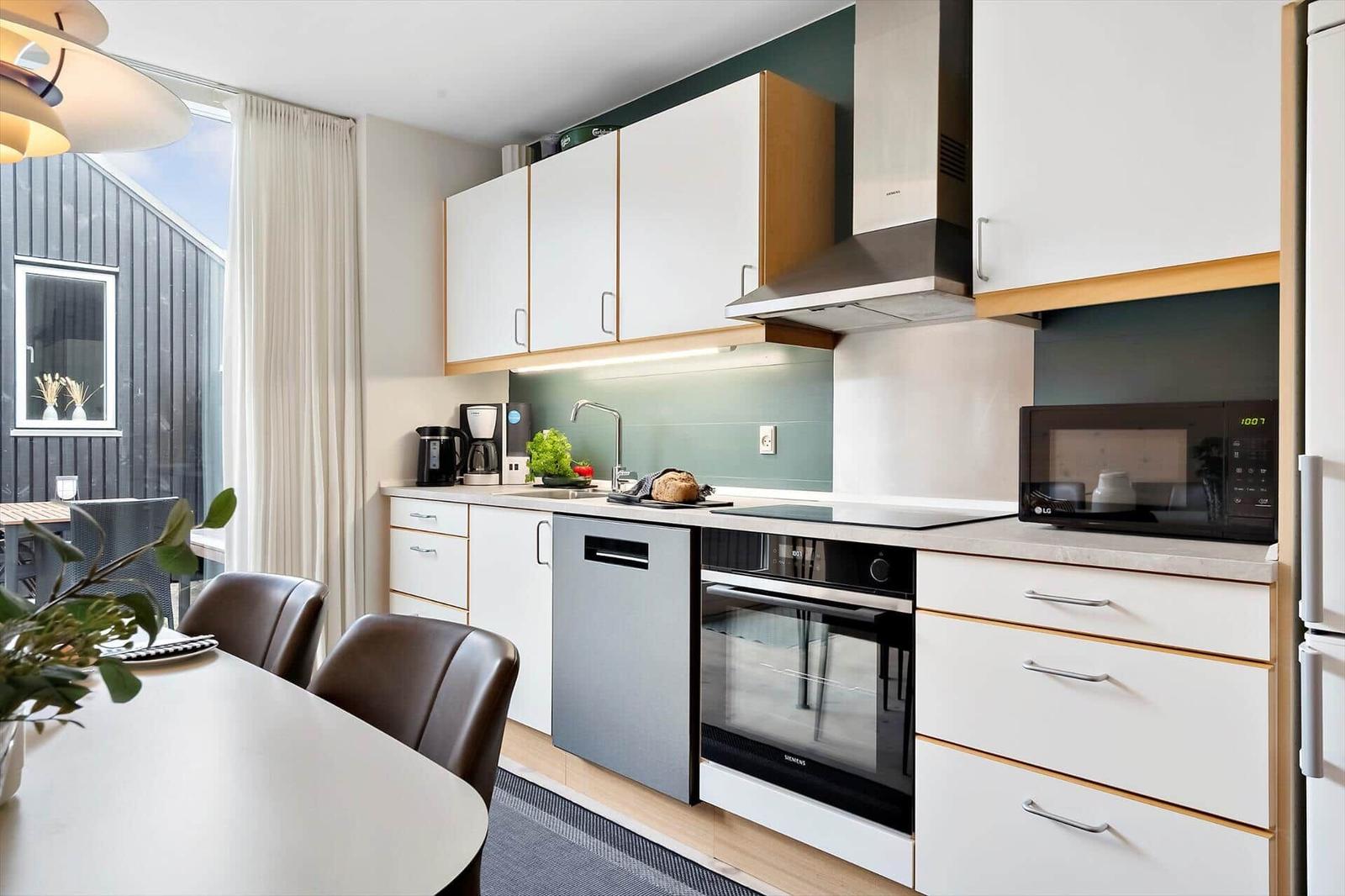 Küche mit Arbeitsfläche, Spüle, Kaffeemaschine und Backofen.