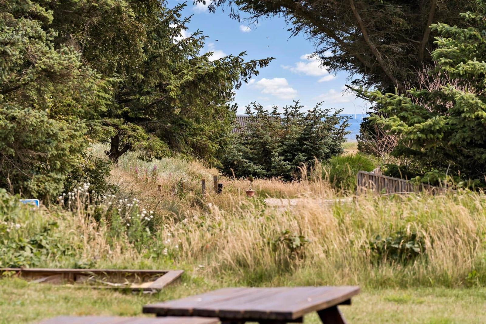 Weiterer Blick auf das Meer und Strand mit Dünen im Vordergrund.