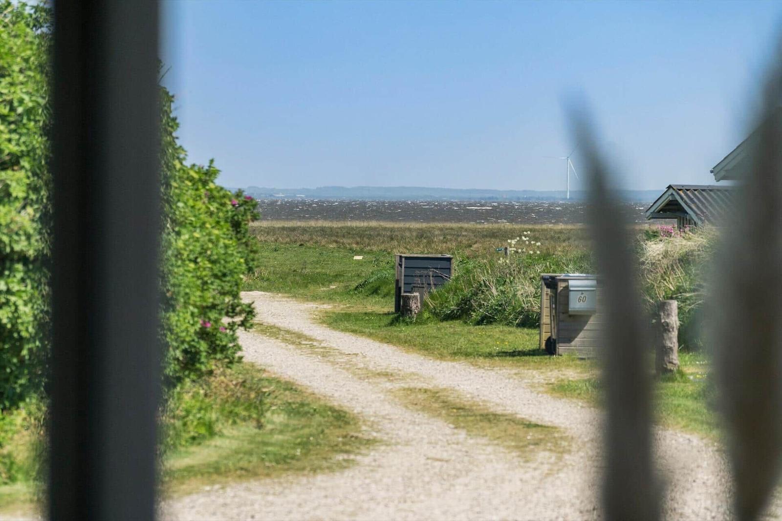 Weiterer Blick auf das Meer mit Strand und Dünen im Vordergrund.