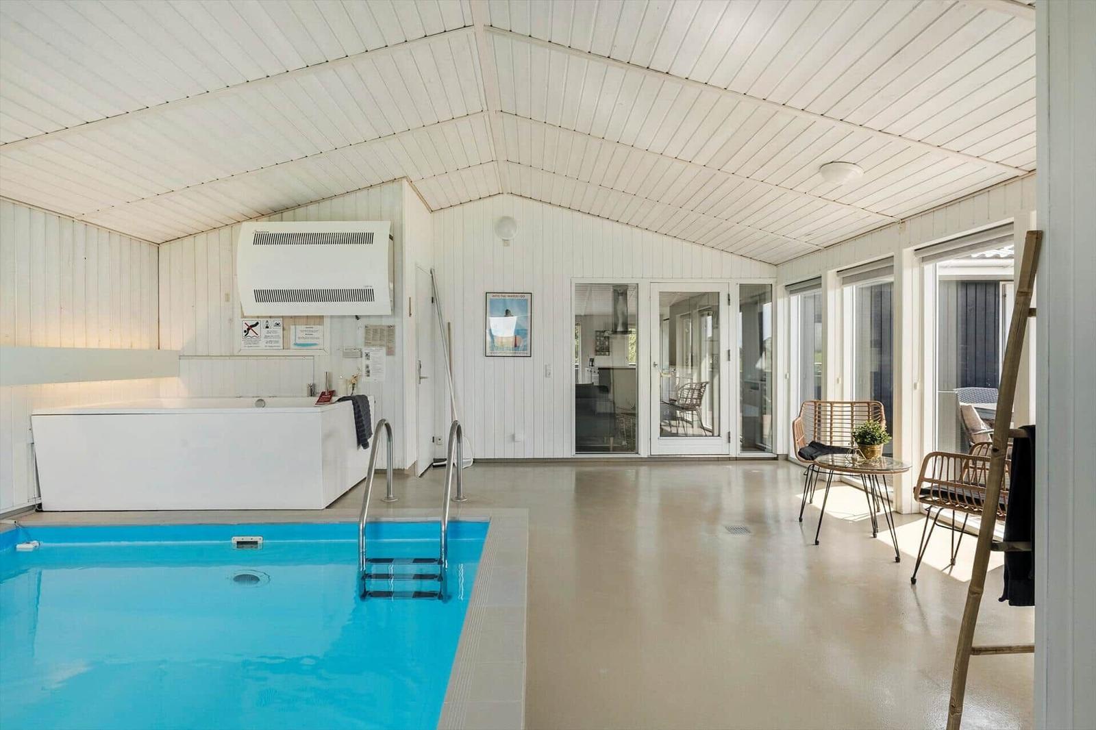 Schwarzes Haus mit Terrasse, Grill und Feuerkorb auf grünem Grund.
