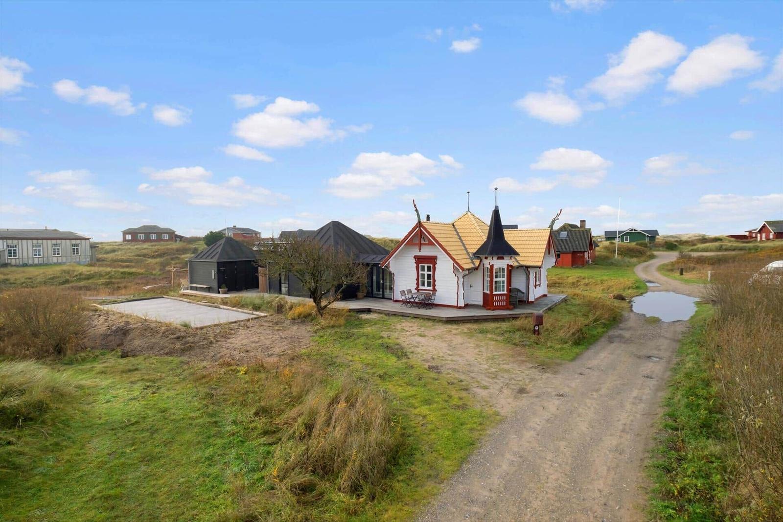 High-quality sauna and hot tub on terrace with view of dunes and holiday homes.