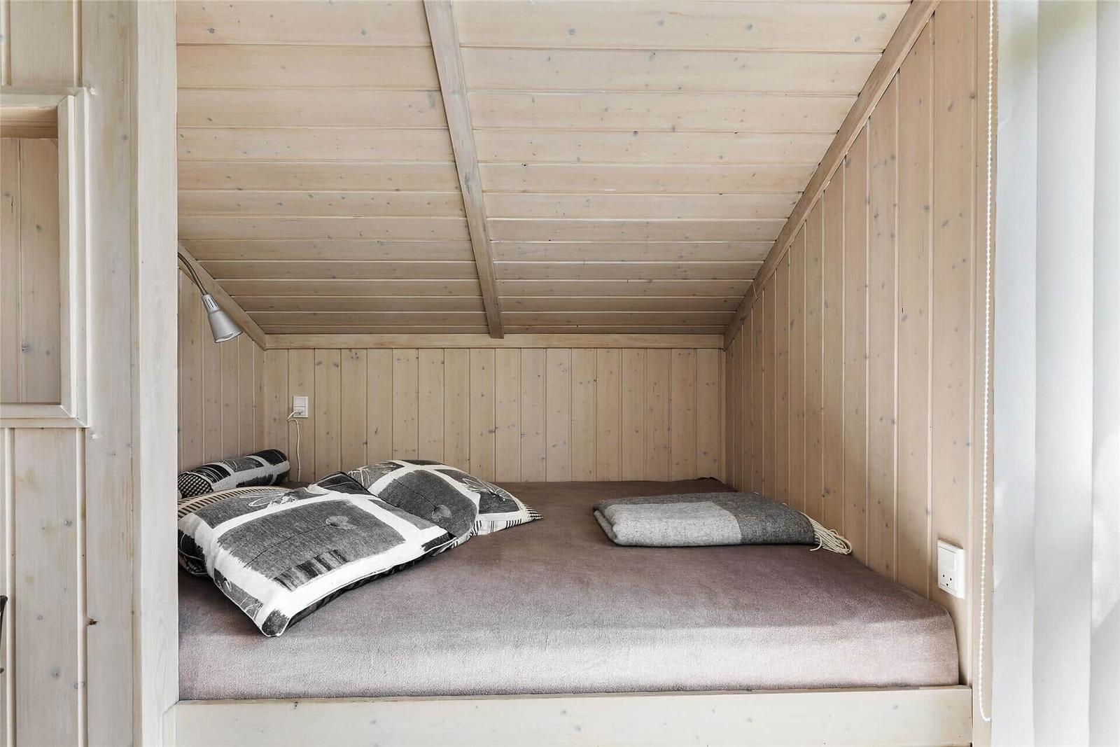 Wohnraum mit Ledersofa, Sessel, Kamin und Fenster zur grünen Aussicht.
