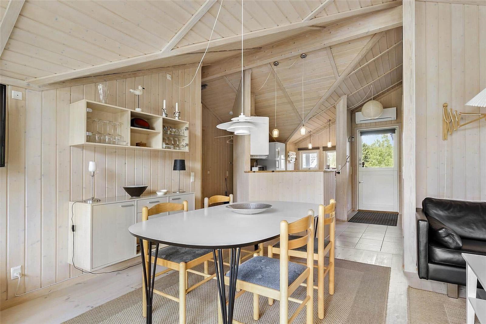 Schlafzimmer mit Holzwand, Bett und Fenster zum Garten