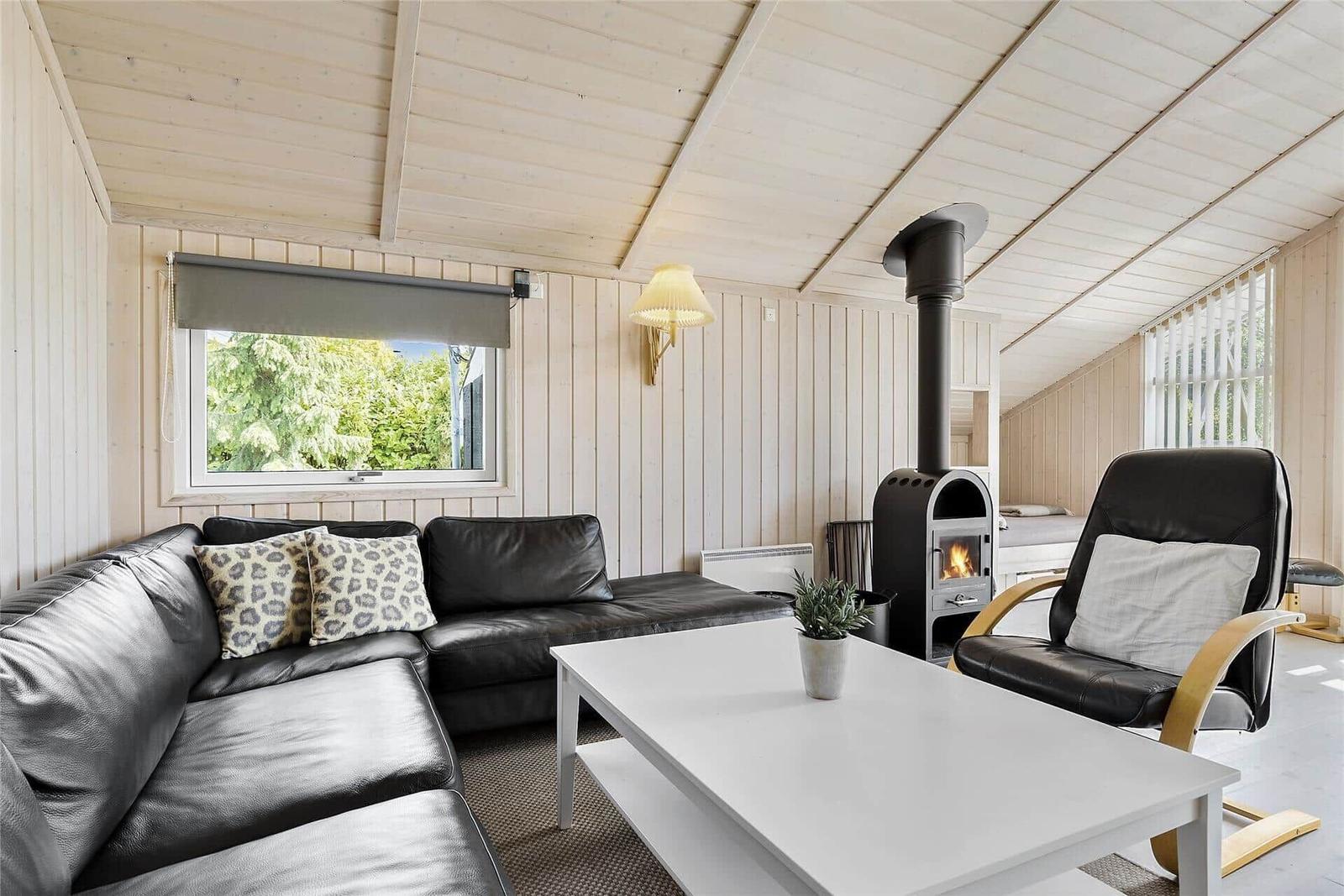 Haus mit Terrasse und Garten, umgeben von Bäumen und Sträuchern.