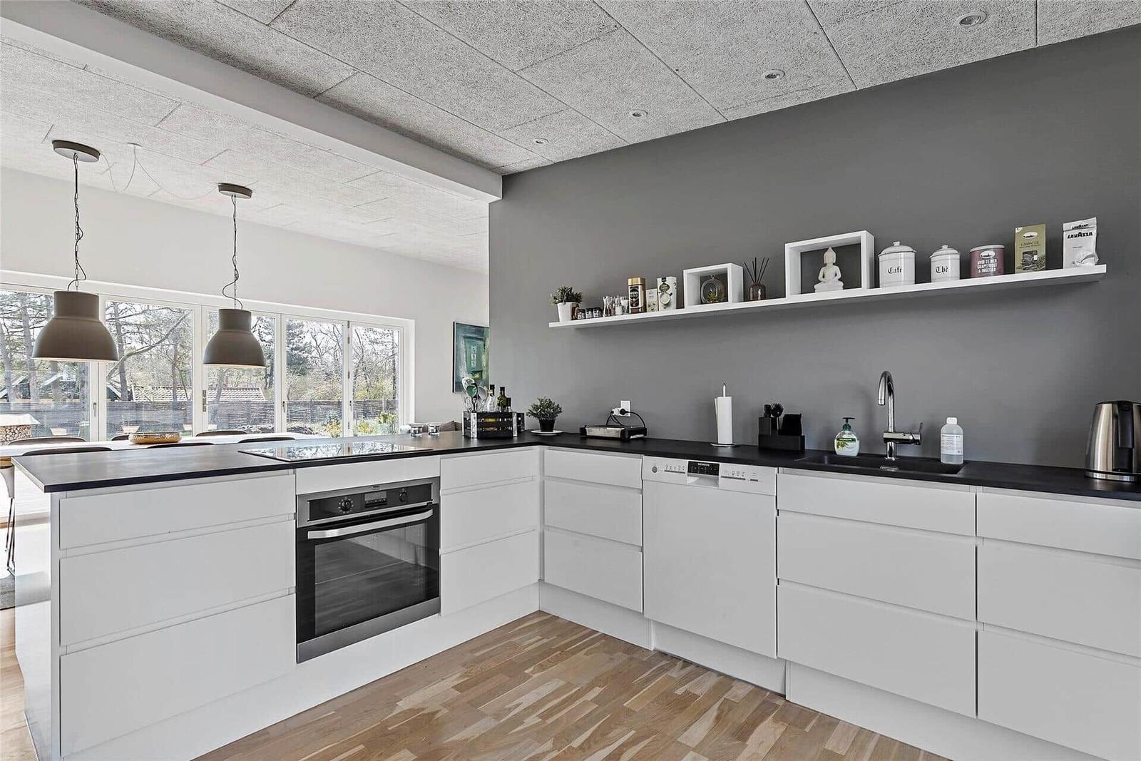 Waschmaschine und Trockner in weißer Waschküche mit Schrank und Wäschekorb.