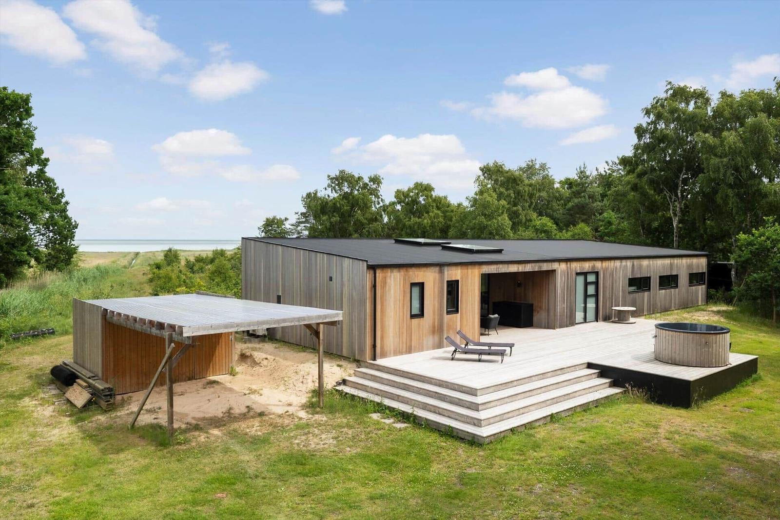 Modern wooden cabin with large glass area in green surroundings