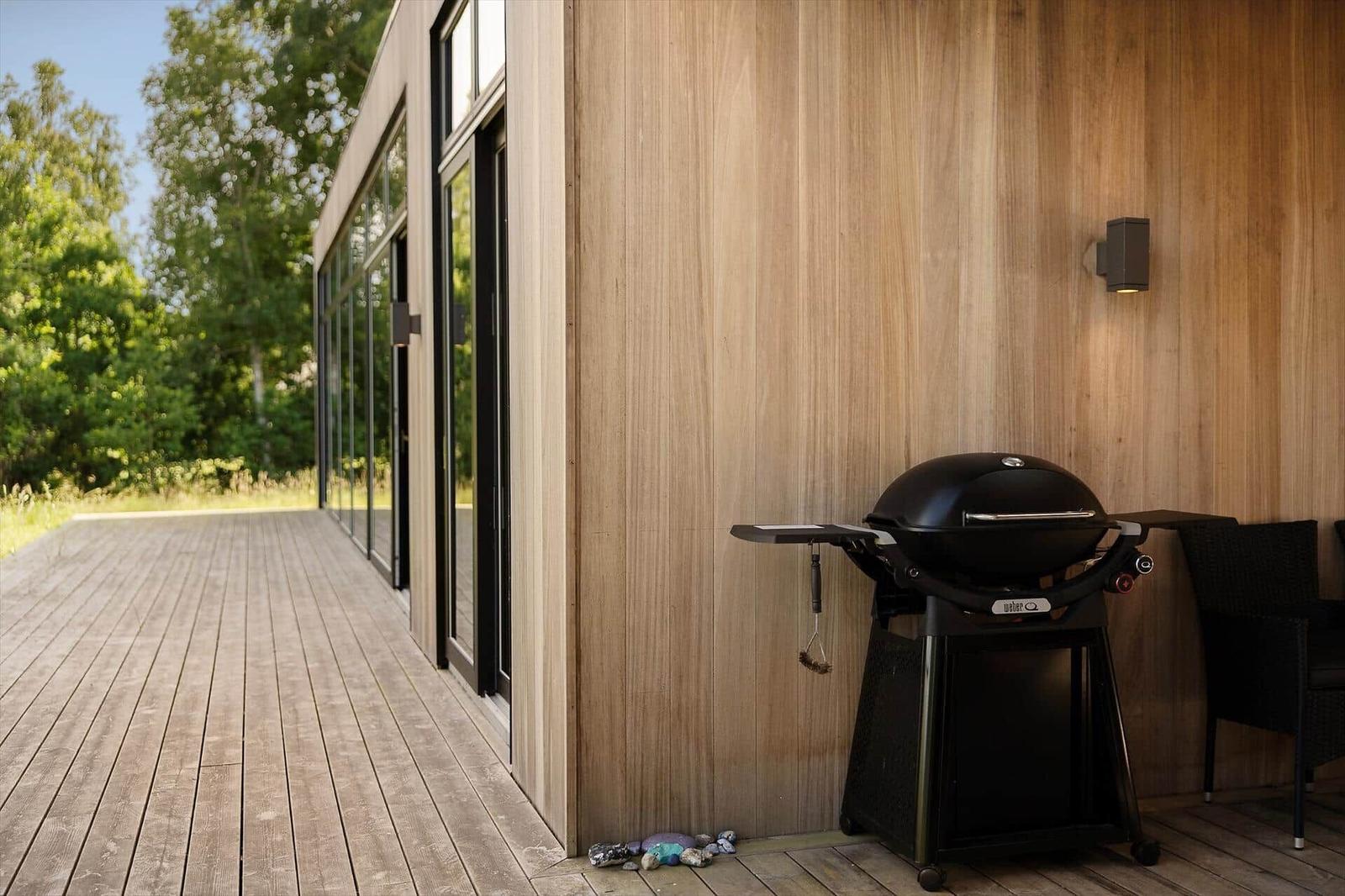 High-quality wooden hot tub on terrace with view into the forest.