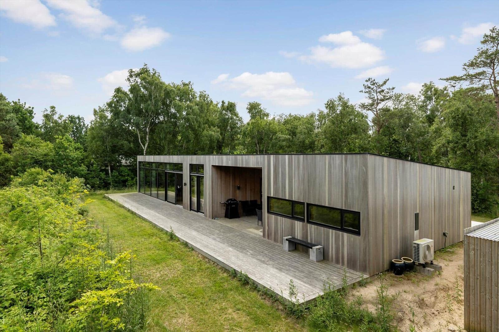 Kitchen with large window view of green landscape and terrace.