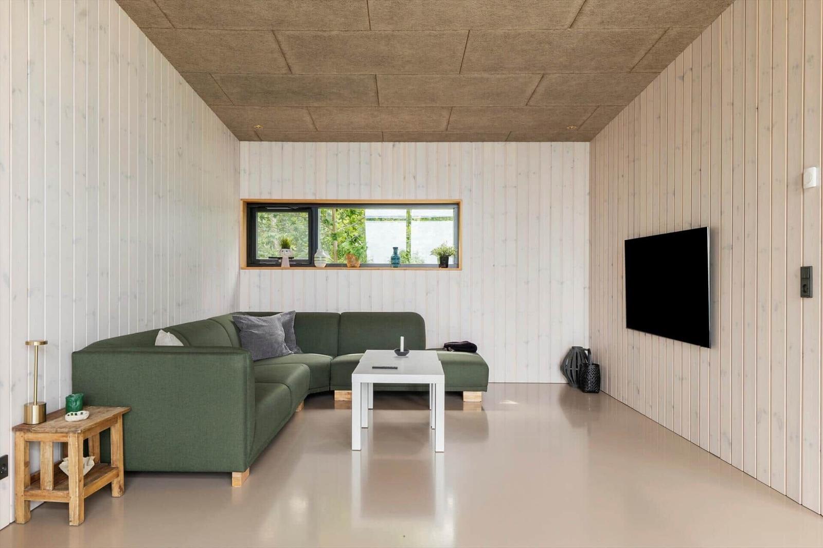 Room with bunk bed, wooden walls, and window with view of trees.