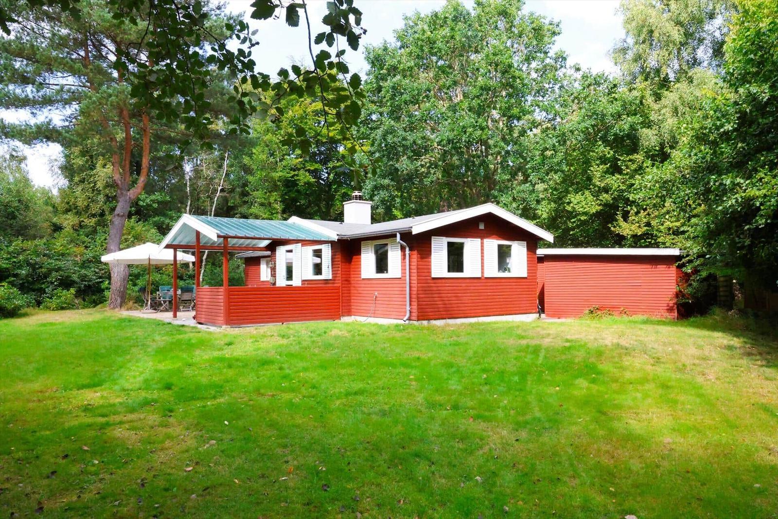 Ein Raum mit Essbereich, Schreibtisch und Schaukelstuhl. Holzdecke und Fenster.