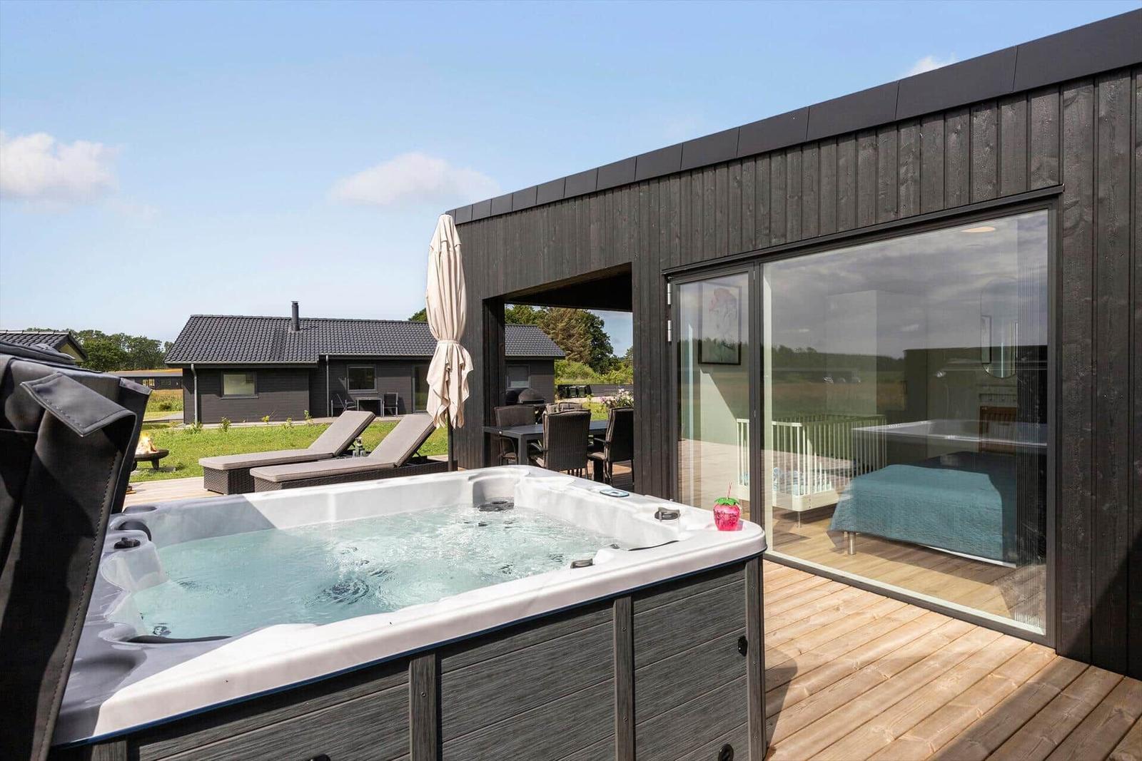 Moderne Villa mit Terrasse, Liegen, Whirlpool und Grillplatz im Grünen.