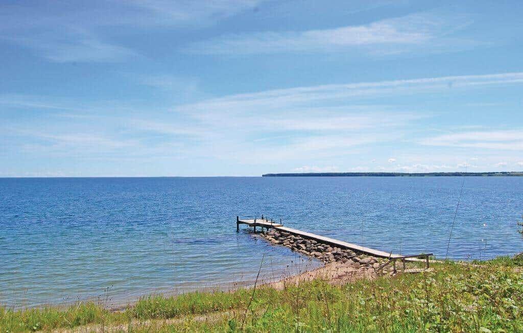 Dock with pier at the shore of a large lake under blue sky.