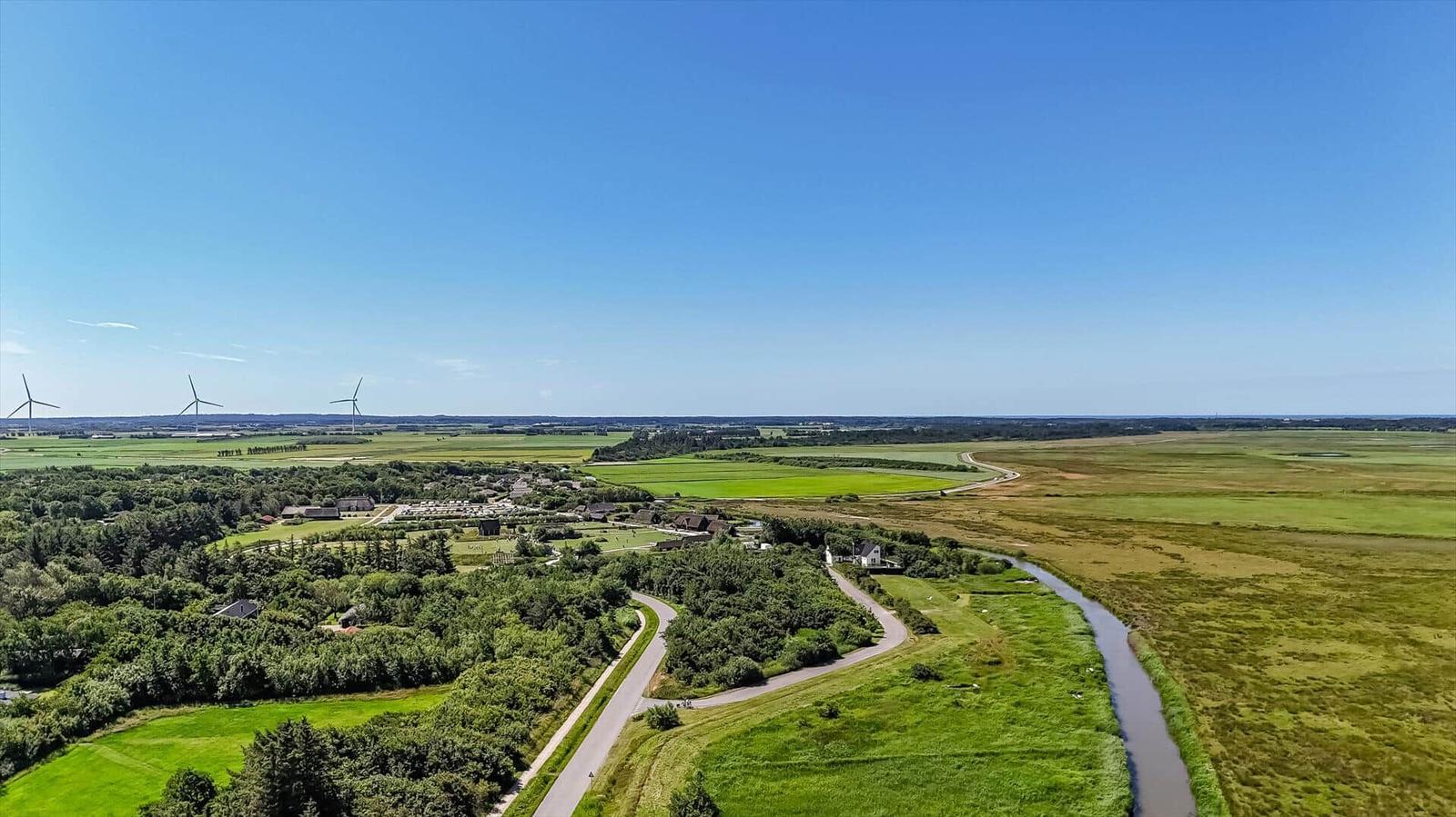Hafenbecken mit Booten und Gästen unter roten Sonnenschirmen.