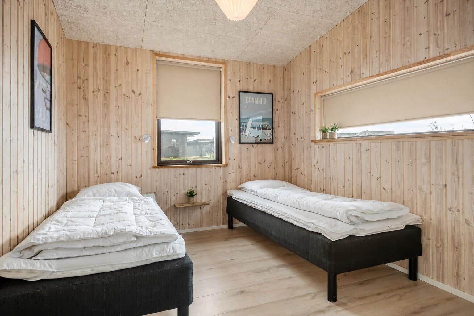 Strandnahe Ferienanlage mit Wohnhäusern und Campingplatz. Weite Felder und Küstenlinie sind sichtbar.
