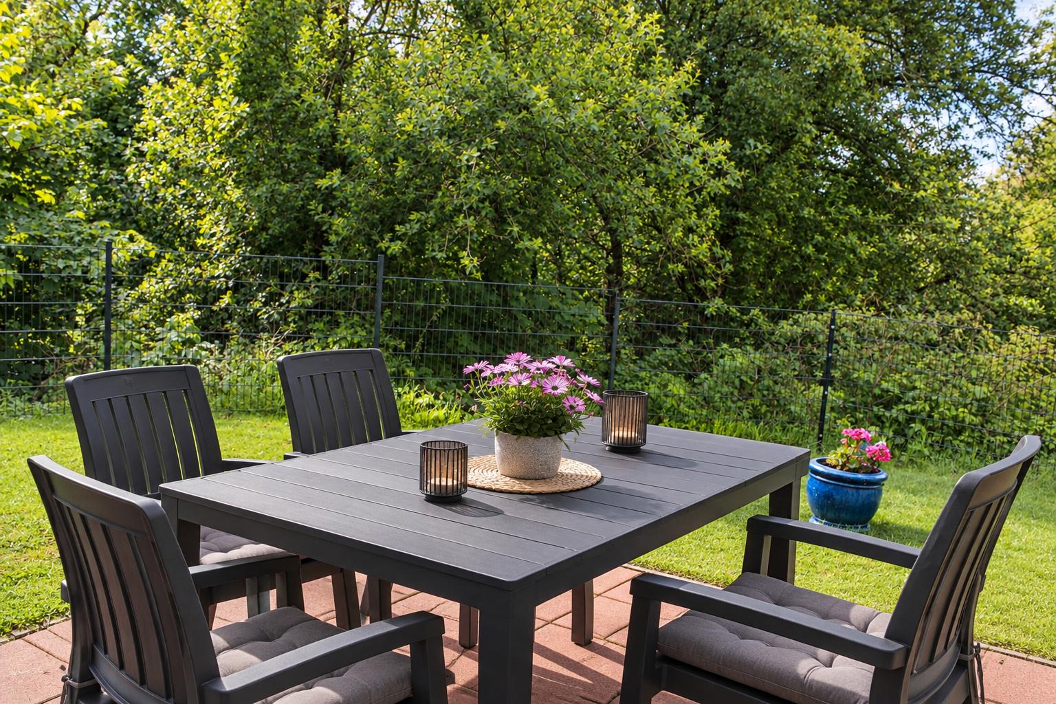 Terrasse mit hoch eingezäunten Garten
