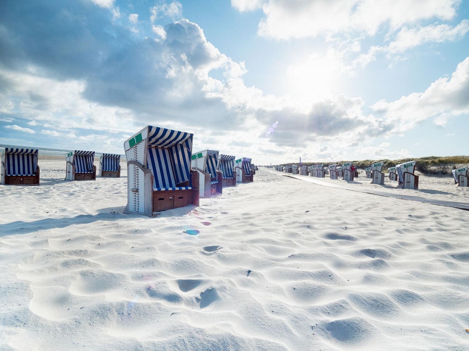 Lichtturm auf grünen Dünen unter blauem Himmel