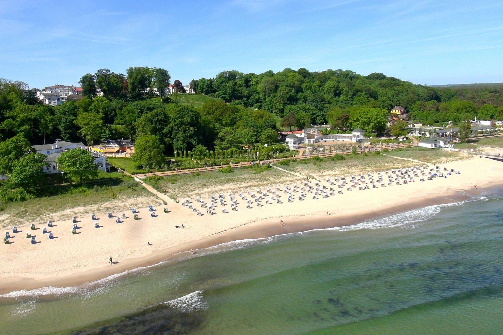 Weitläufiger Blick auf das Meer mit Booten und grüner Vegetation im Vordergrund.