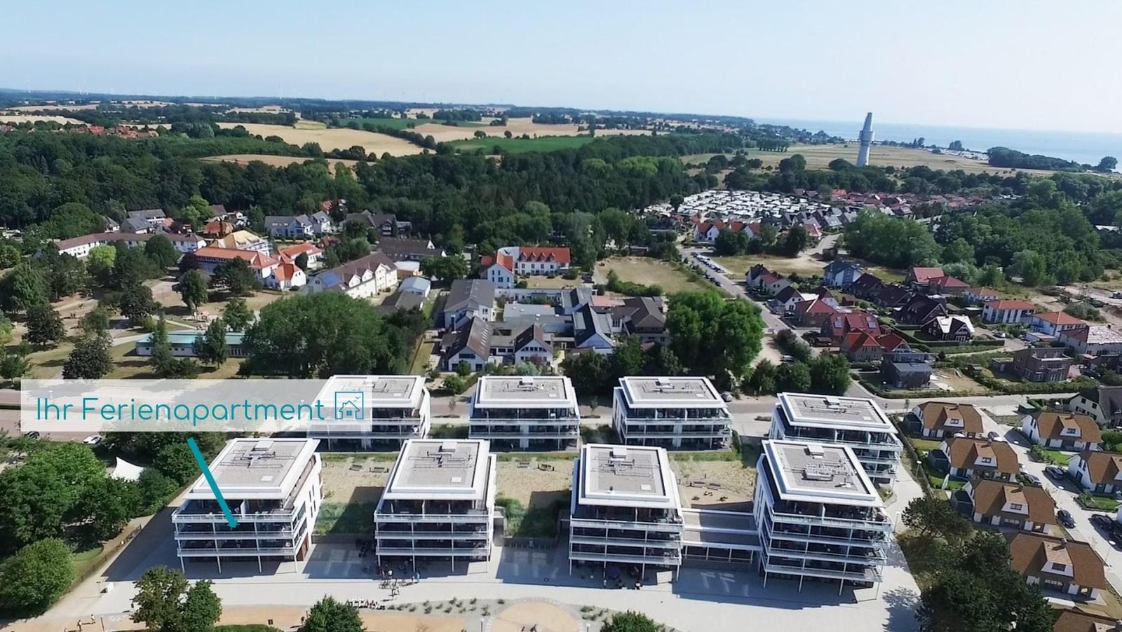 Raum mit zwei hängenden Sesseln und Liegen, großflächige Fenster mit Blick auf Außenbereich.