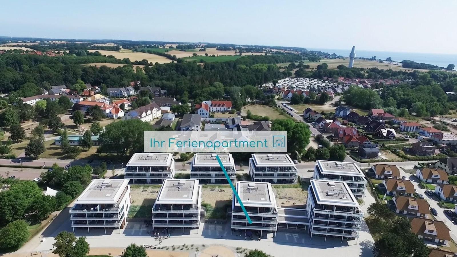 Ferienapartment in modernem Gebäudekomplex mit Blick auf Landschaft und See.