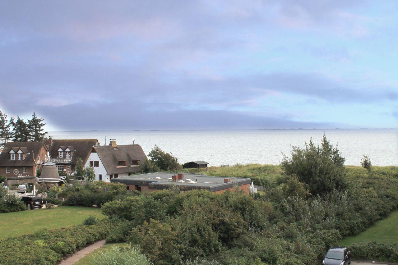 Blick von Balkon auf See mit Grünflächen und Häusern