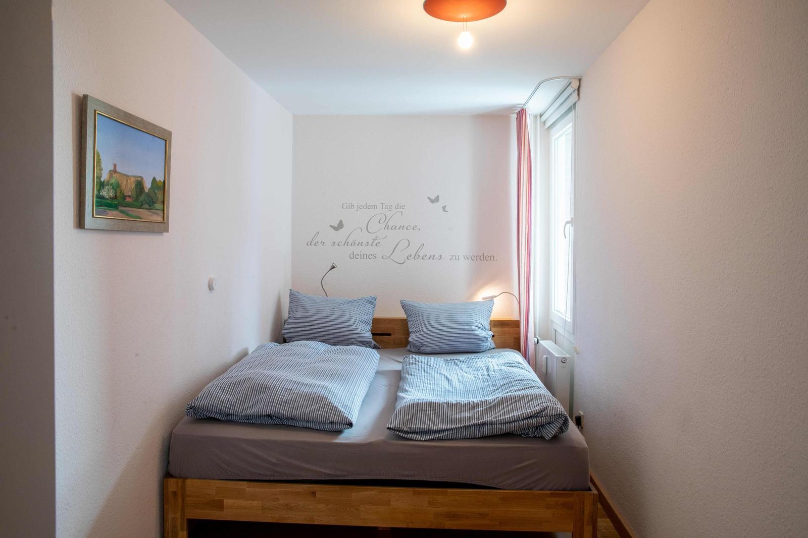 Wohn- und Essbereich mit Kücheninsel, Holzboden und Fernseher an der Wand.