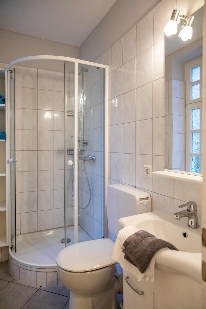 Schlafzimmer mit Doppelbett, weißen Schränken und Wandbild