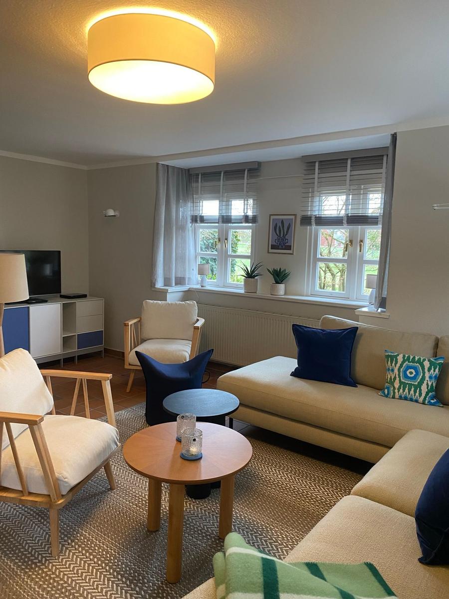Zimmer mit zwei Betten, Fenster, Schrank und Lampen.