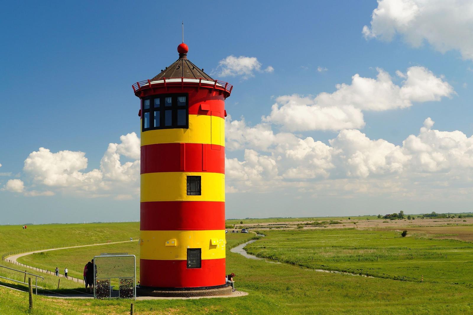 Zweistöckiges Backsteinhaus mit weißen Fenstern und Eingangstür an der Straße.