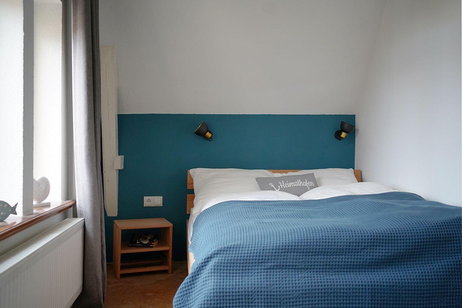 Ein Raum mit Holzschrank, blauer Sitzgelegenheit und Fenster mit Vorhang.
