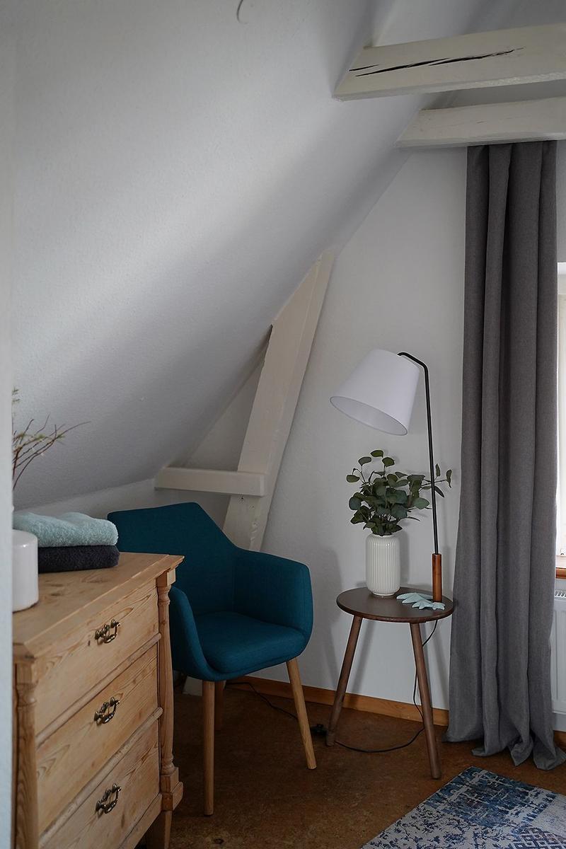 Badezimmer mit Dusche, Waschbecken und Toilette. Holzoptik Boden, weiße Fliesenwand.