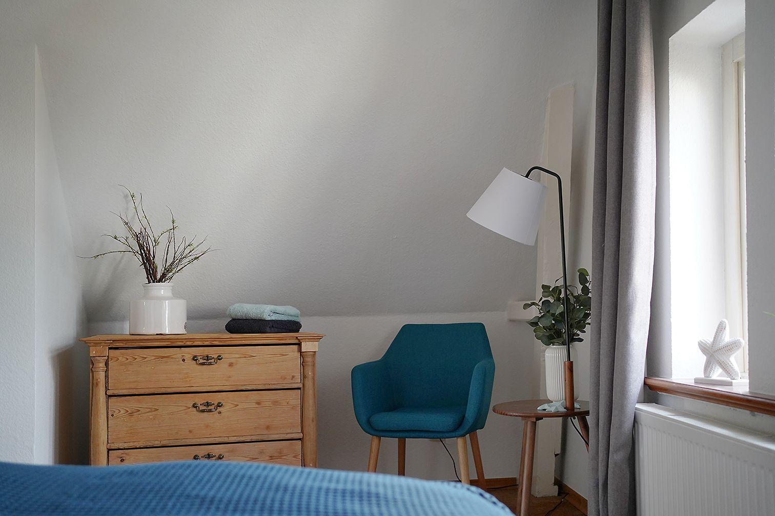 Badezimmer mit Toilette, Waschbecken und Dusche. Fenster mit Pflanze und Handtücher.