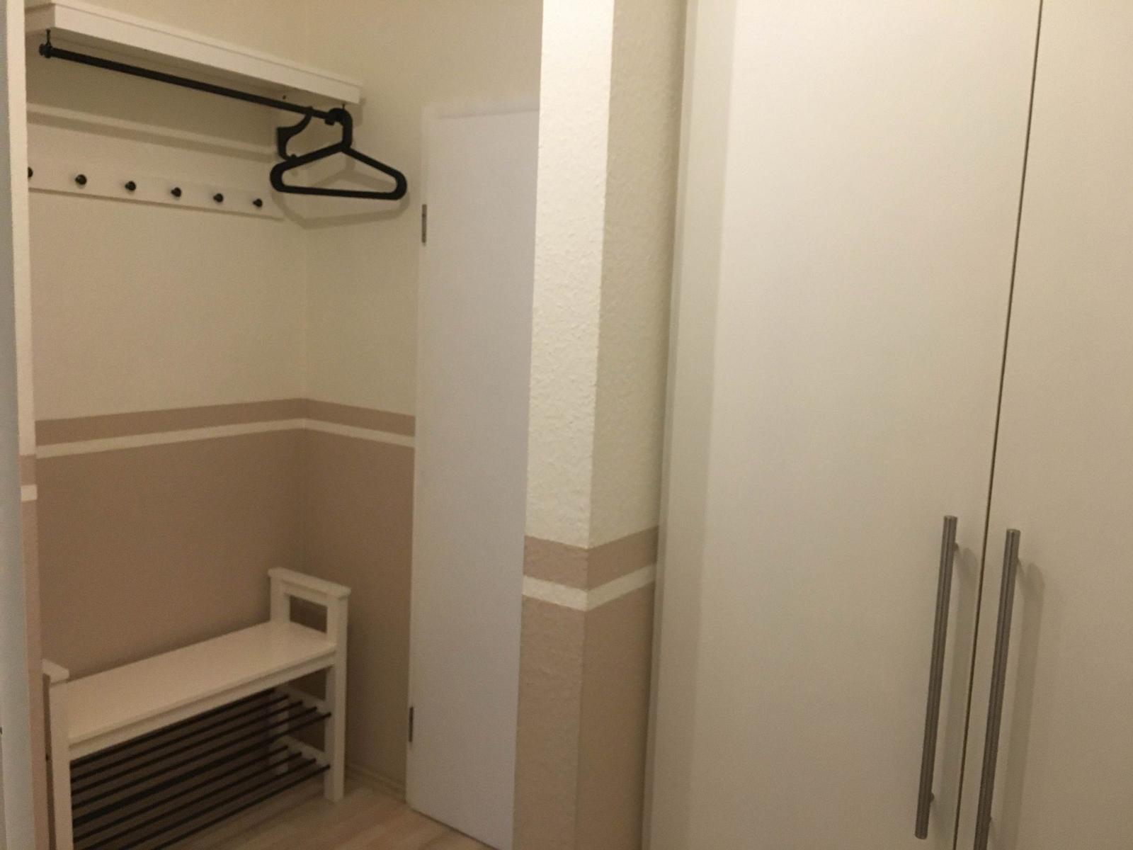 Schrank mit Haken und Sitzbank im Schlafzimmer