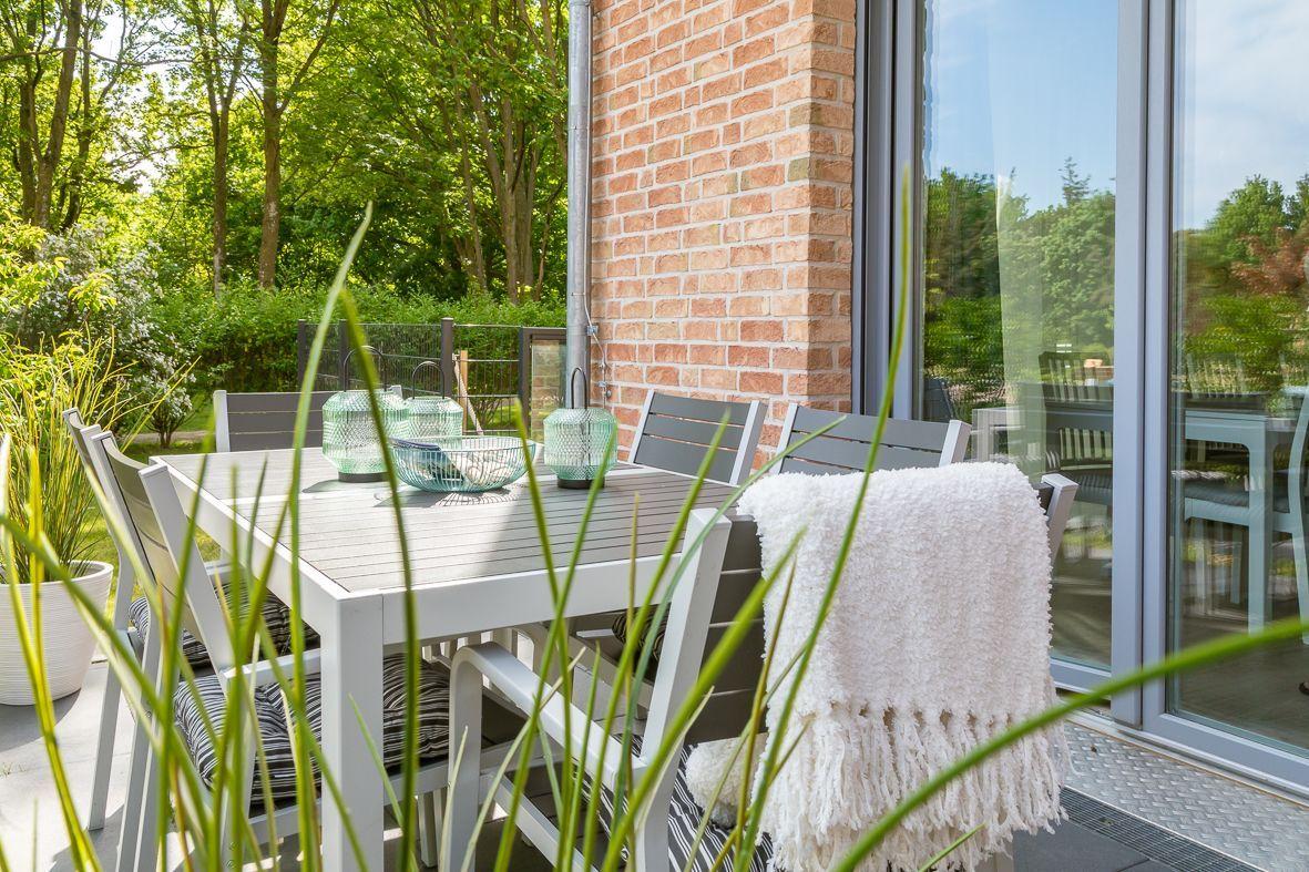 Wohnzimmer mit Sofa, Couchtisch und Wandbild. Blaue Vorhänge und Deckenleuchte.