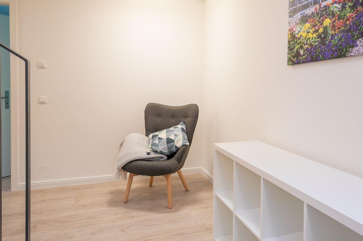 Wohnung mit Wohn- und Essbereich, Balkon, Terrasse und Bad. Flur und Treppe sind ebenfalls eingezeichnet.