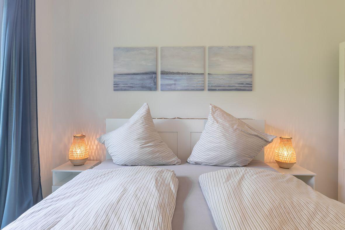 Zimmer mit Doppelstockbett, Schrank und Fenster zur grünen Außenseite.