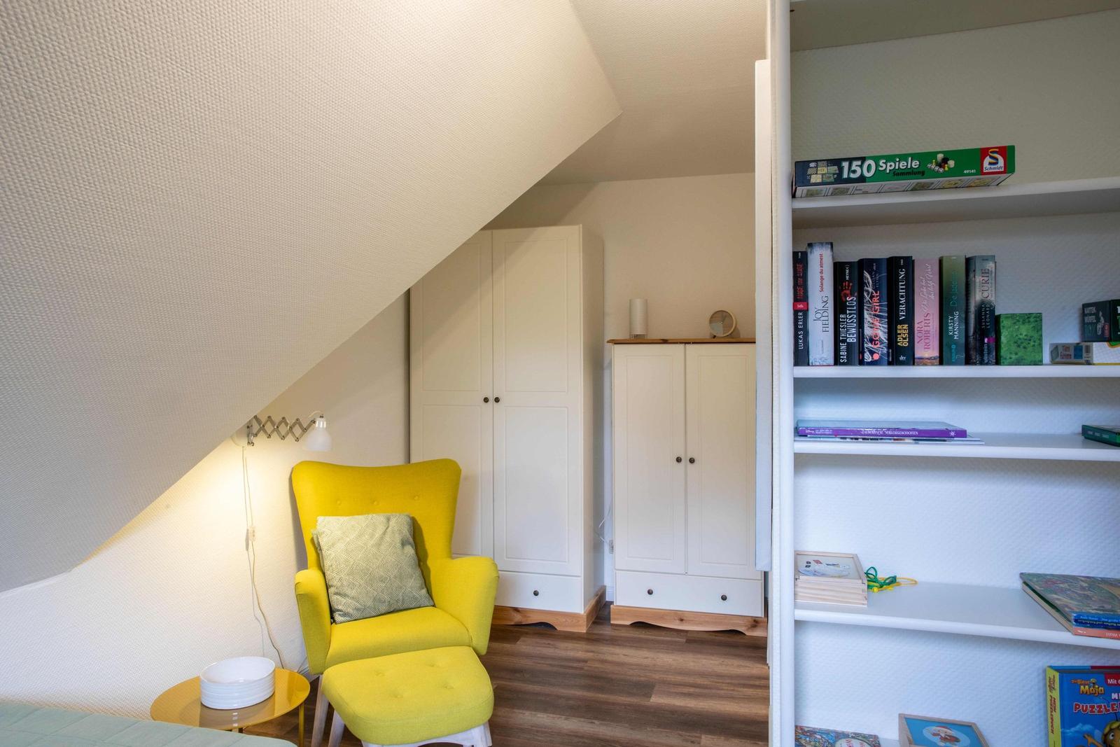 Schlafzimmer mit Bett, Stuhl, Fenster und Wandbild mit Möwen.