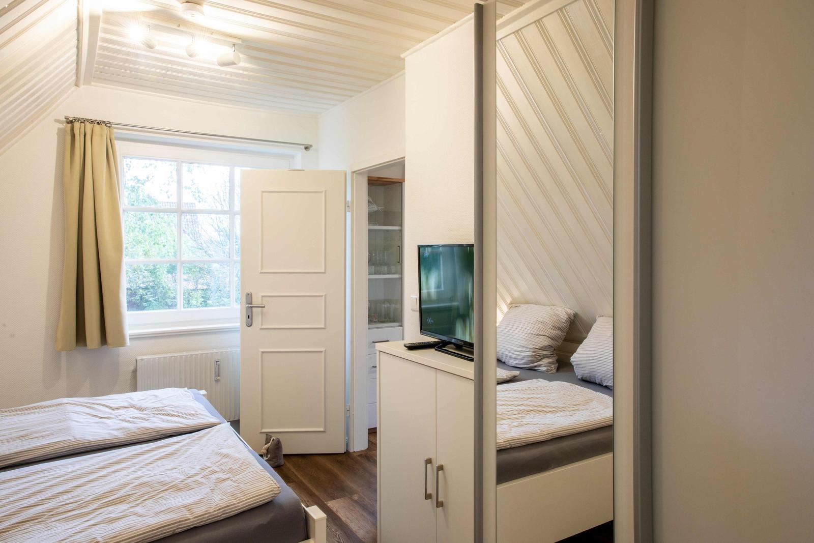 Badezimmer mit Dusche, Waschmaschine und Spiegelschrank.