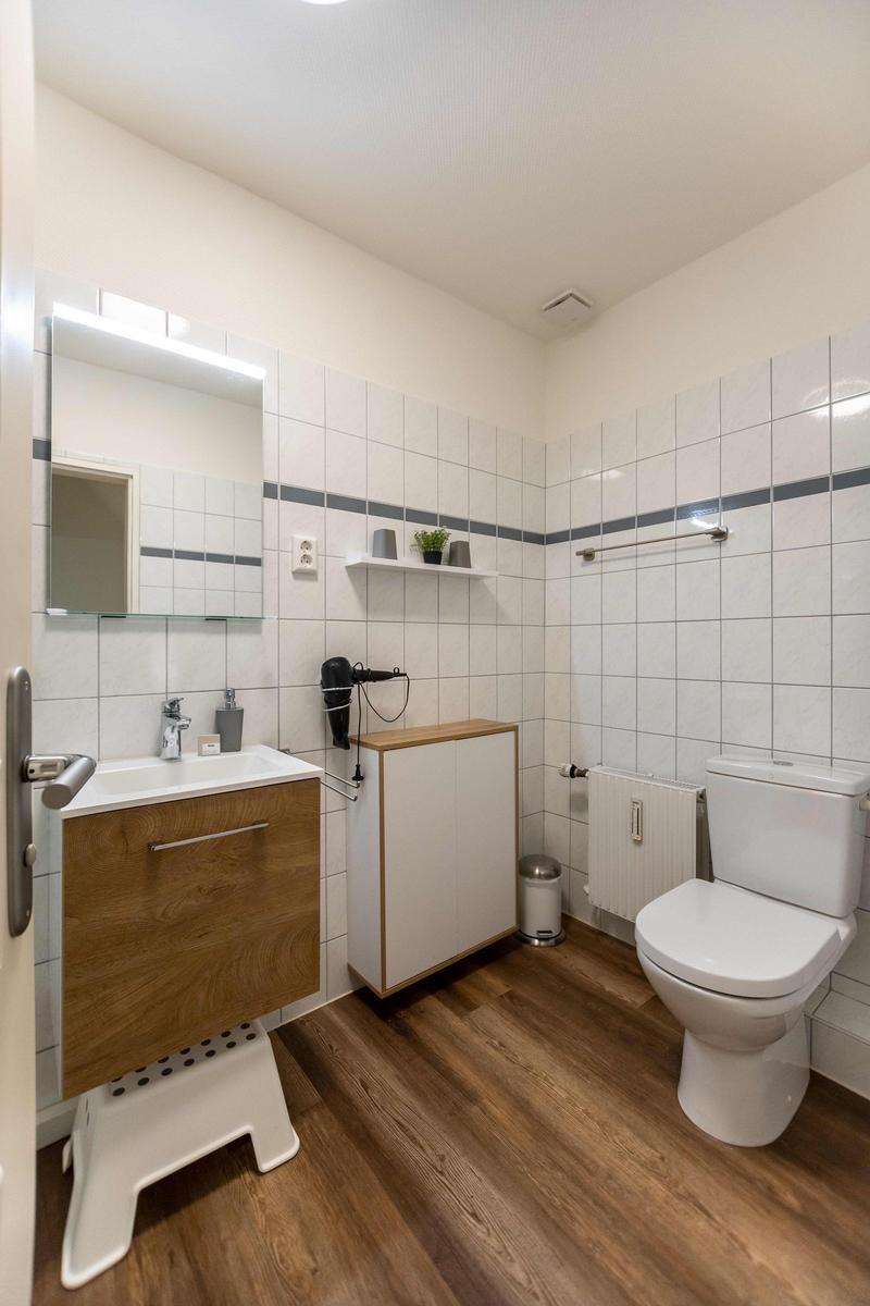 Bad mit Waschbecken, Spiegel, Haartrockner und Schrank