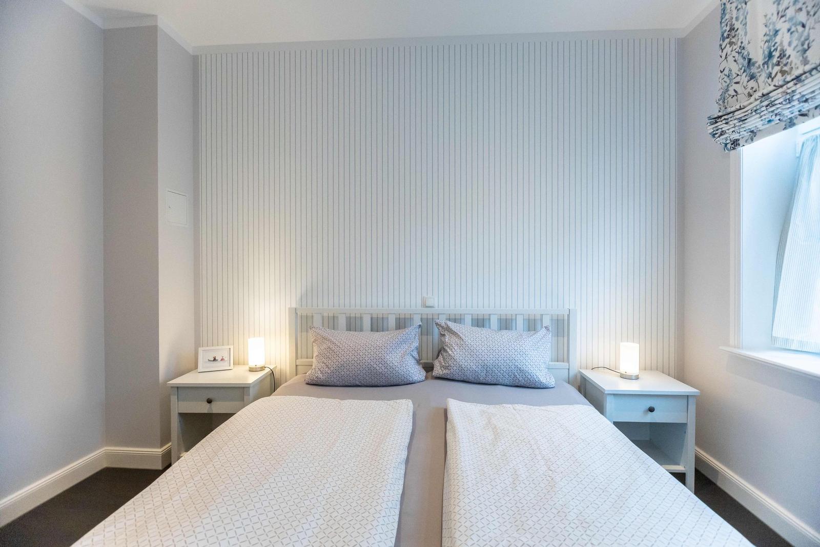 Bedroom with bed, nightstand, TV, and dresser.