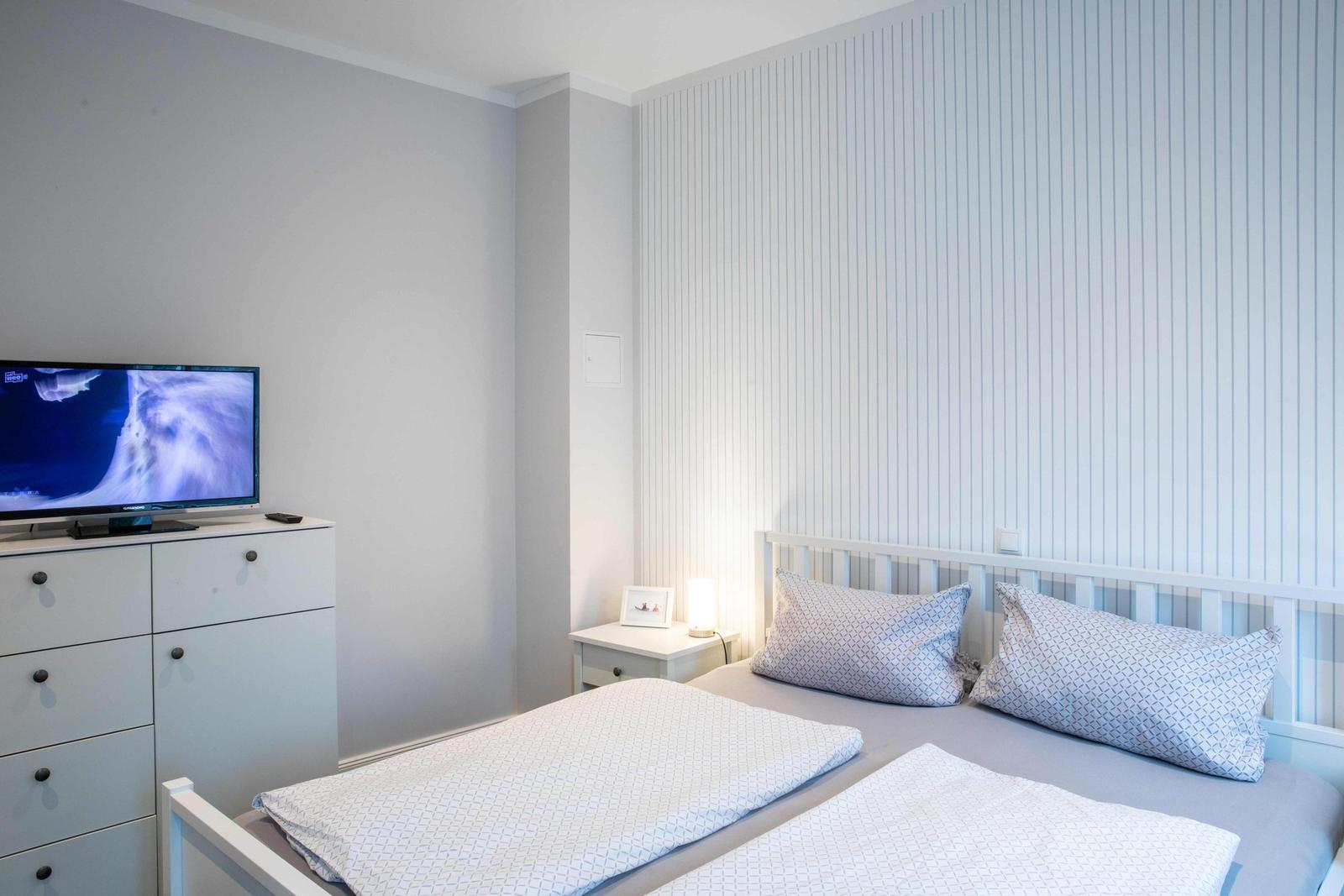 Bedroom with double bed, two windows, and nightstands with lamps.