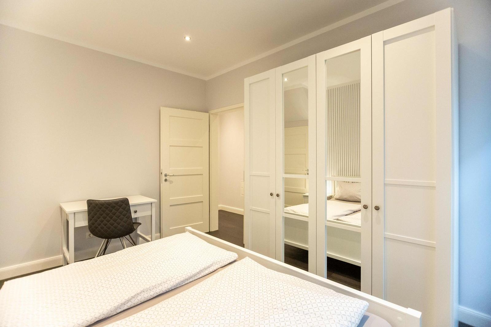 Bedroom with double bed, two nightstands, and a window with curtains.