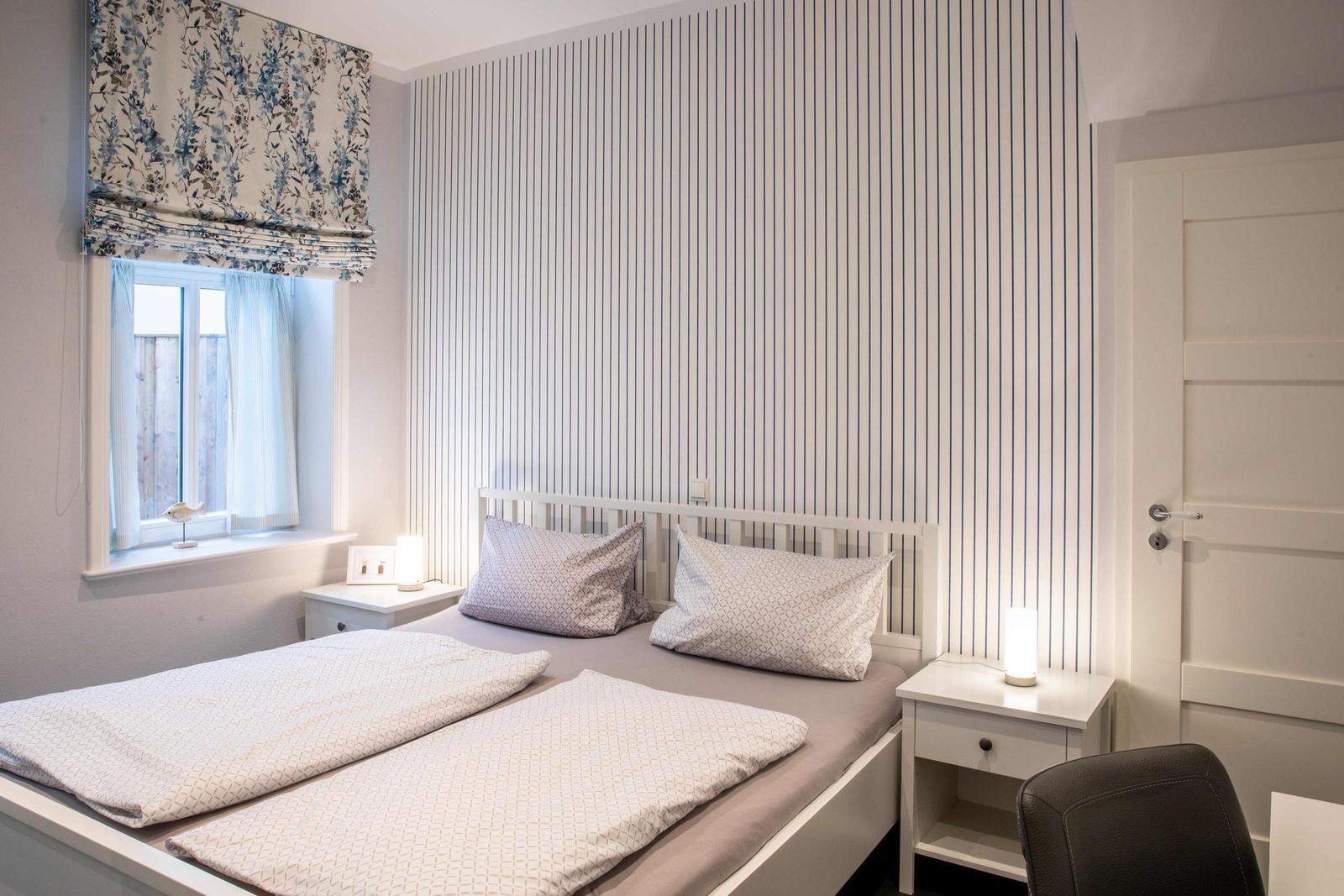 Bedroom with bed, two nightstands, and striped wall