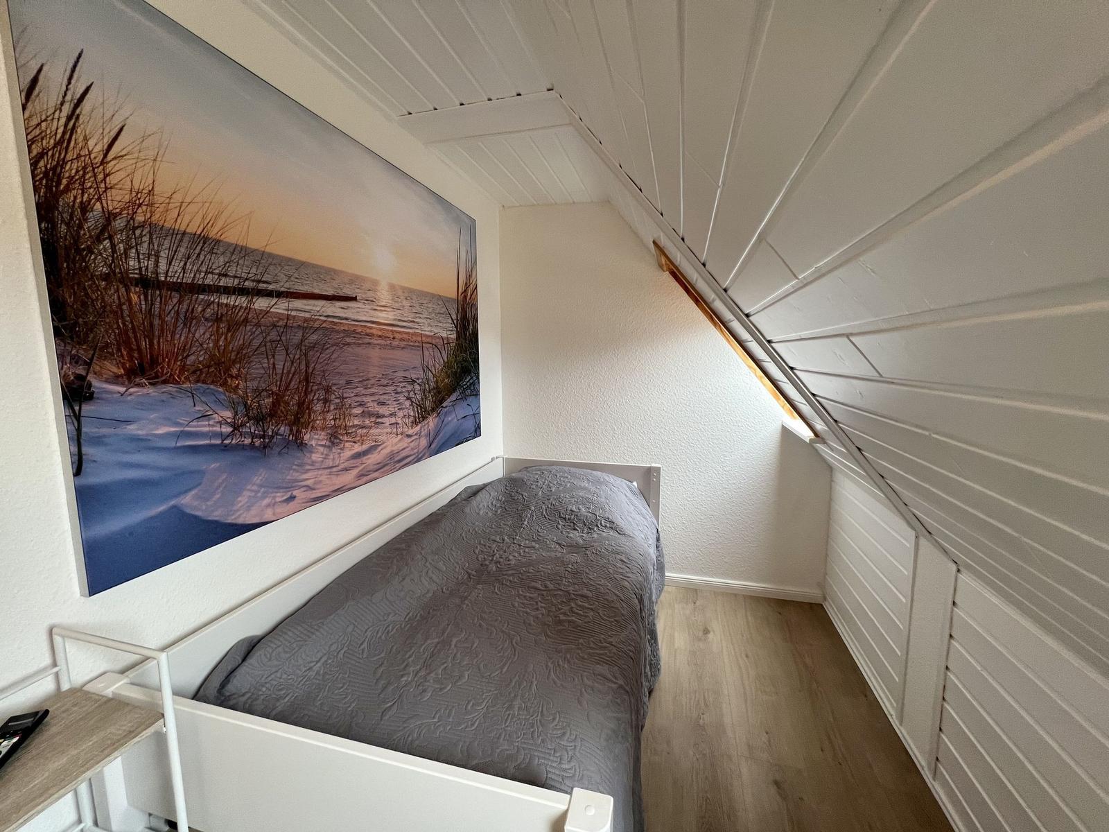 Dusche, Waschbecken und Heizkörper in Dachgeschossbad mit Holzdecke und Mosaikboden.