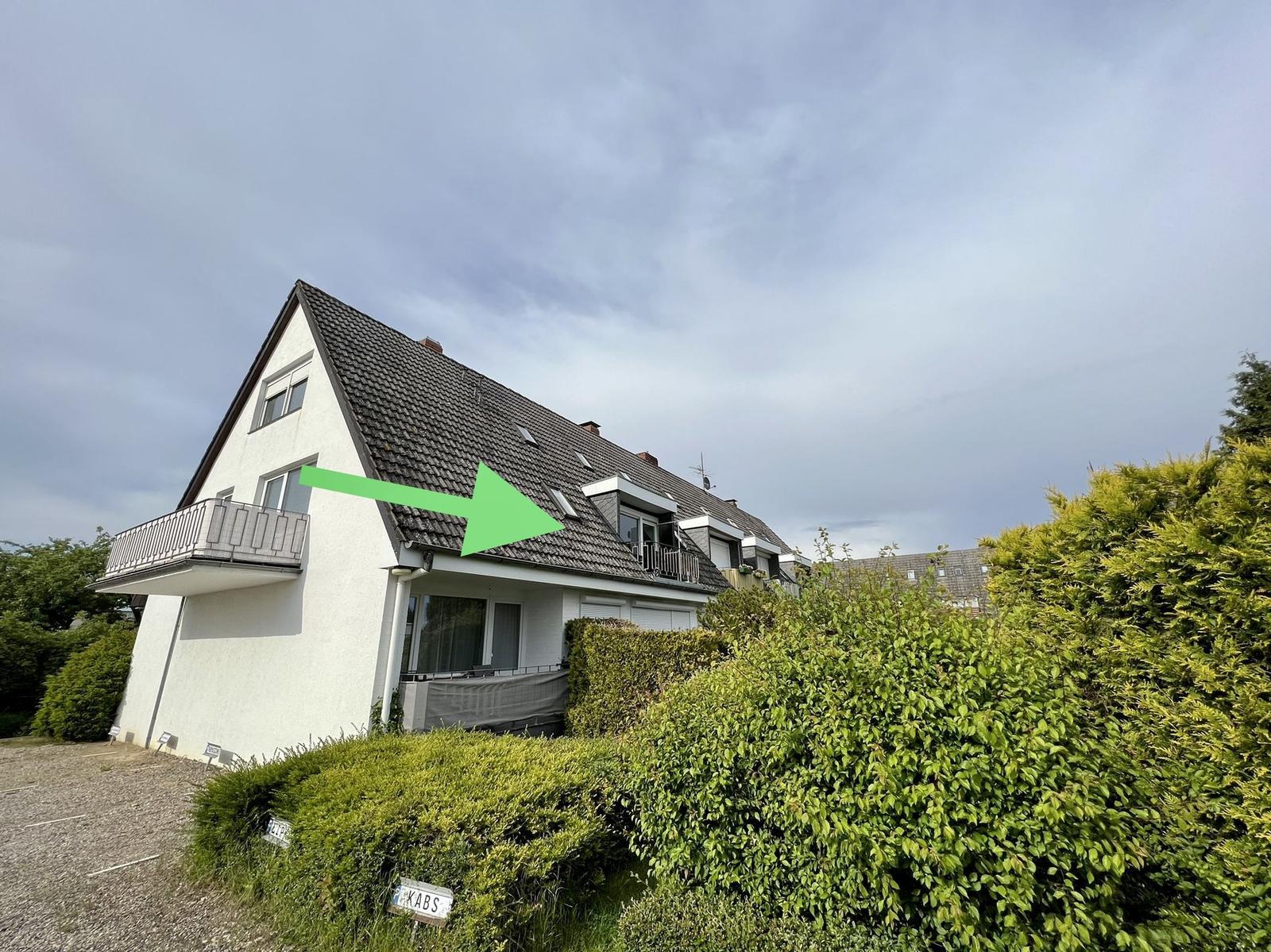 Flur mit Wandbild von Windsurfern, Blick auf Strand und Holzregal im Hintergrund.